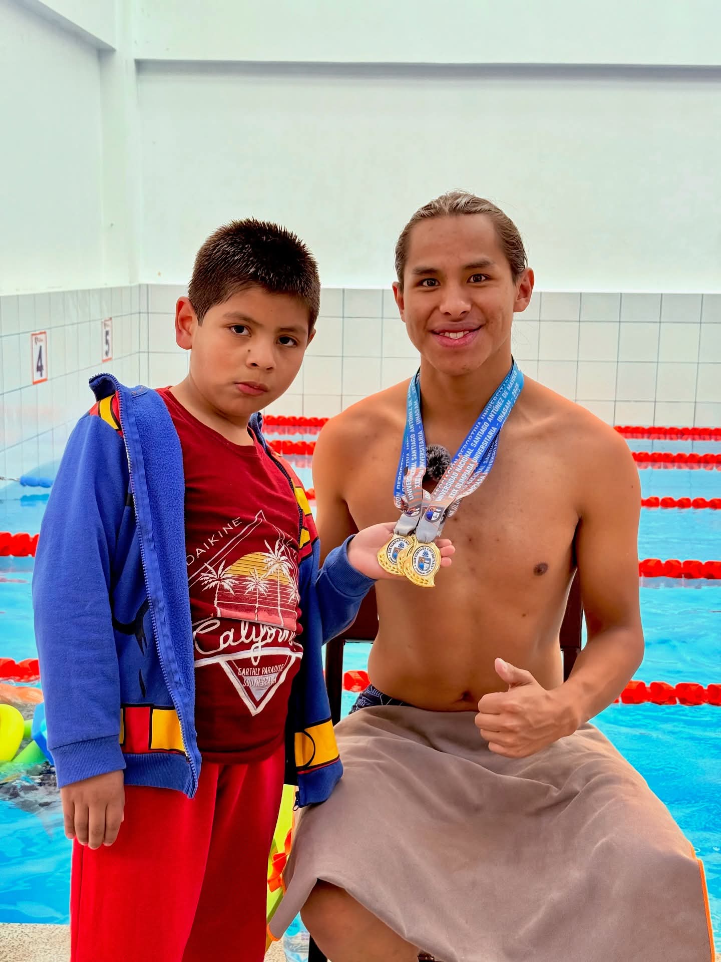 Jesús Pérez, estudiante de Ciencias de la Comunicación en la UNASAM, muestra con orgullo las medallas obtenidas tras coronarse campeón en las cuatro categorías de natación durante las Olimpiadas Universitarias 2025